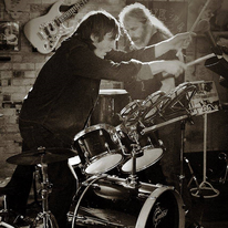 The Brothers Burn Mountain, drummer playing with drumsticks.