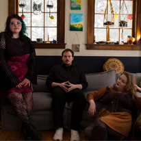 The Harlow Pennies band, sitting on a couch together.