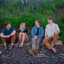 The Roadside Lupines, group of four adults sitting on a log.