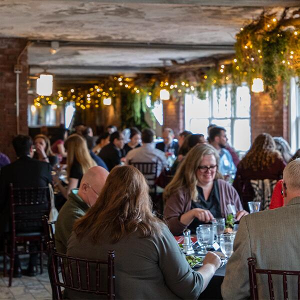 A large gathering of people enjoying a dinner in the Winter Garden