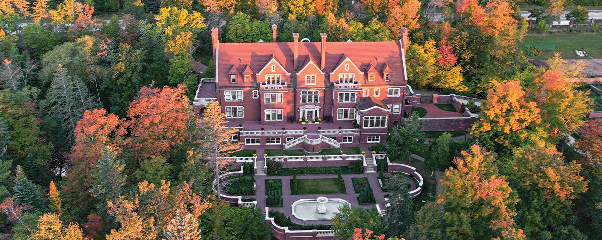Glensheen Mansion exterior surrounded by colorful fall trees.