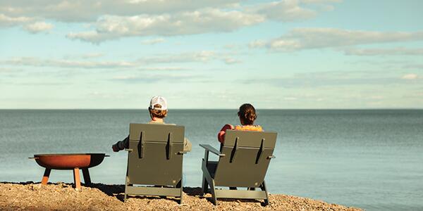 two people sitting in lounge chairs on the shore of Lake Superior.