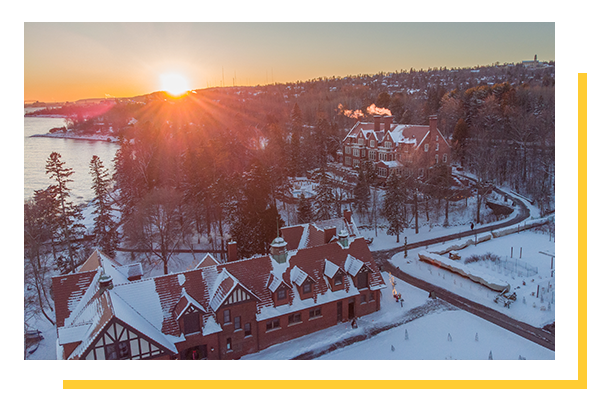 Carriage House and Glensheen shot from above, during sunset with snow on the ground during winter.