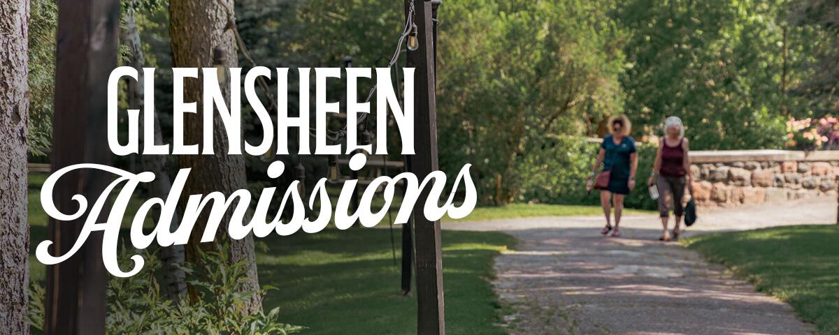 Two women walking along paved path, surrounded by grass, trees, and string lights. Reads: Glensheen Admissions
