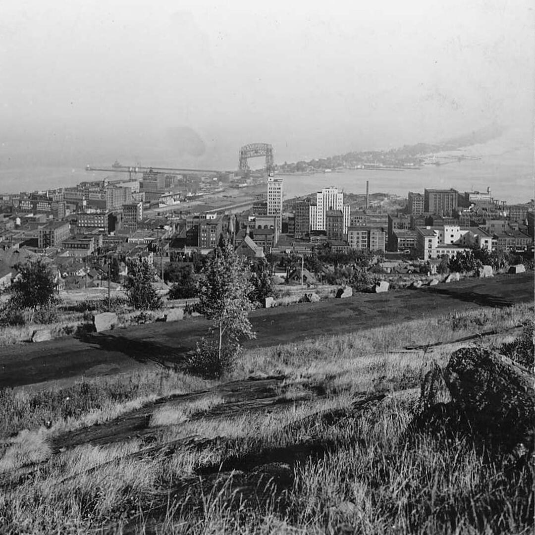 view of the city of Duluth, overlooking city buildings and the aerial lift bridge along the peninsula.