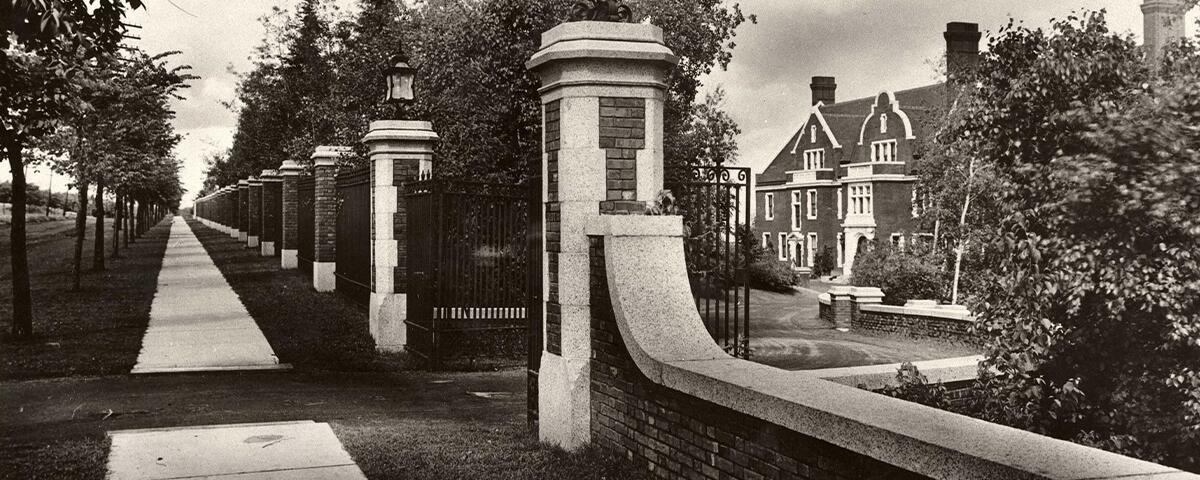 sidewalk lined with trees along Glensheen's gate entrance to the front of the mansion, early 1900s.