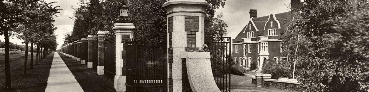 sidewalk lined with trees along Glensheen's gate entrance to the front of the mansion, early 1900s.