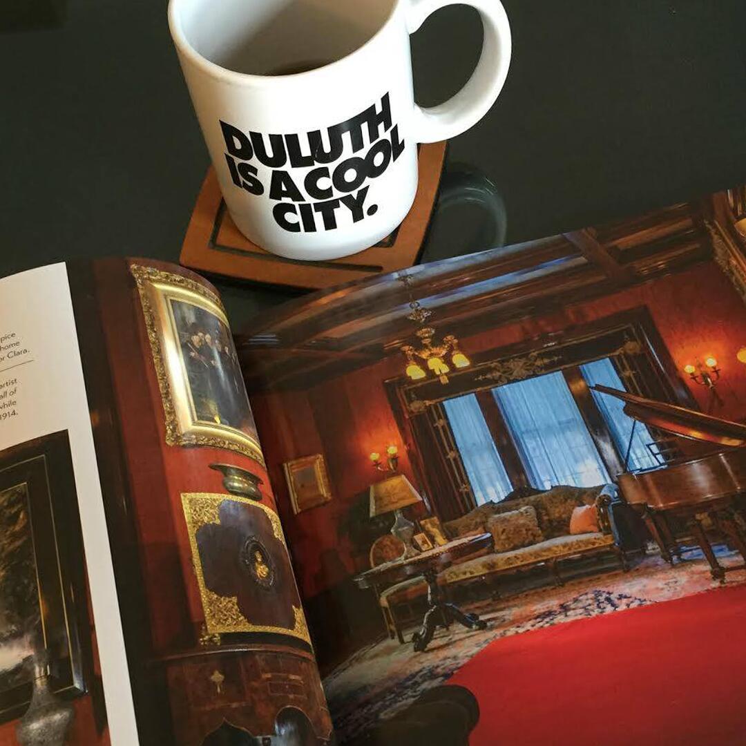 table display of a book with Glensheen's living room photographed and a 'Duluth is a cool city' mug.