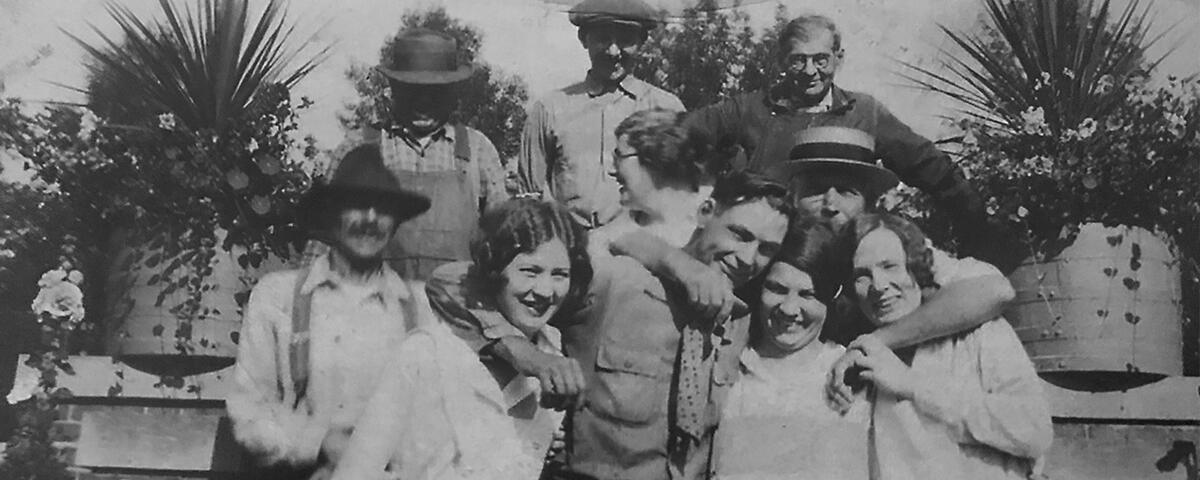 Group of four women and and six men huddled in a group surrounded by two large planters, the grounds crew.
