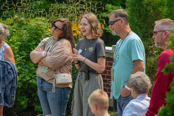 tour guide speaking with a group in the brick exterior formal garden