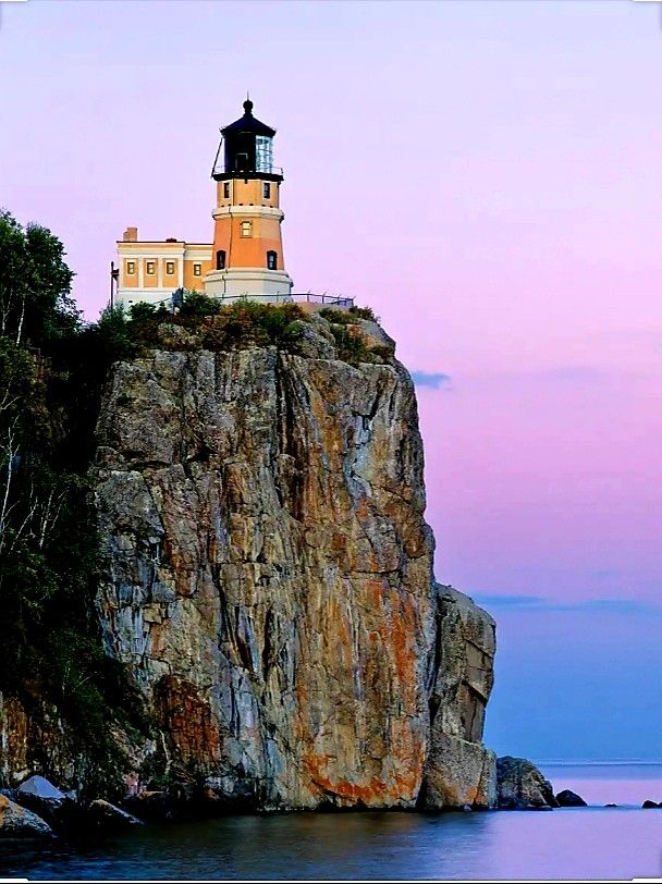 Split rock lighthouse on cliff with a purple sky