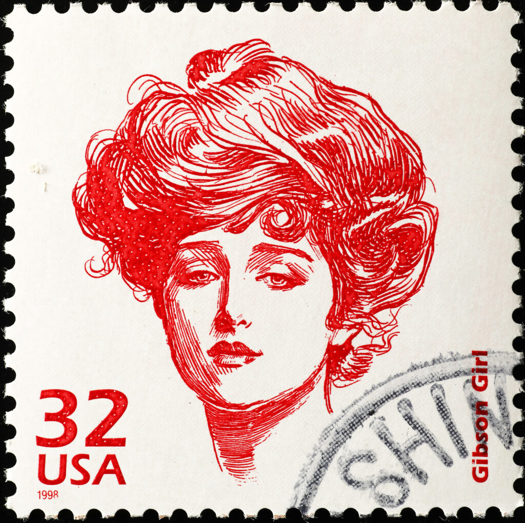 A red line sketch of a woman with long flowing hair on a 32 cent stamp for the USA. Text says Gibson Girl.