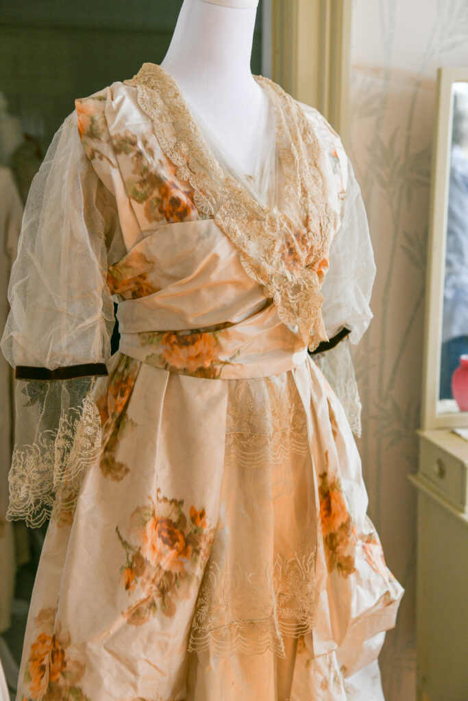 An image of a dress with embroidered flowers and embellishments tied tightly around the waist.